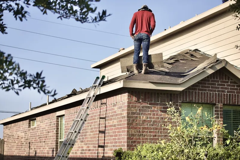Professional roofer working on a residential roof in Ashmead Village